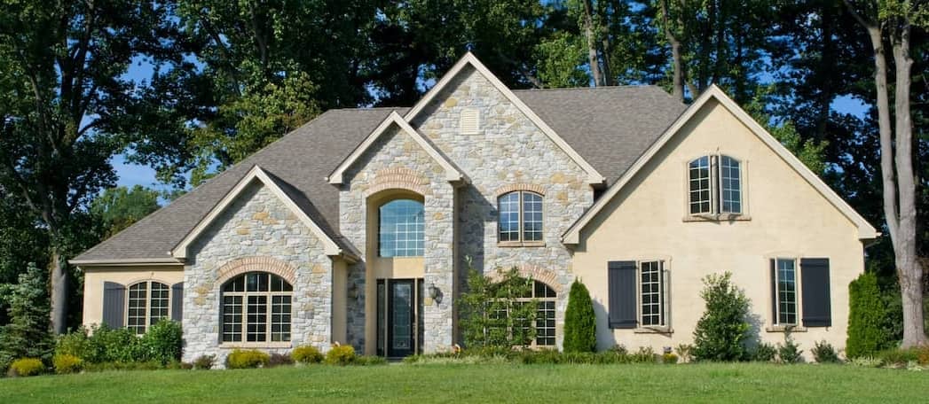 https://www.rocketmortgage.com/resources-cmsassets/RocketMortgage.com/Article_Images/Large_Images/Stock-Stone-Faced-Tan-Home-That-Is-Newly-Built-And-Surrounded-By-Trees-AdobeStock28274676%20copy.jpg